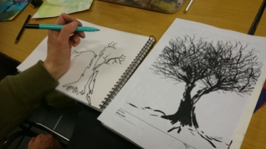 A person drawing two tree silhouettes